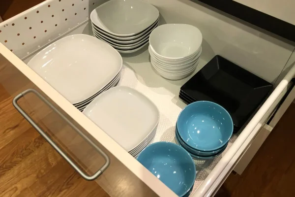 pratos pequenos e grandes e travessas dentro de gavetas organizadas